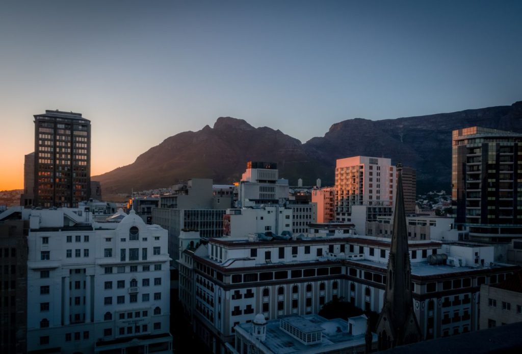 Stunning view of Cape Town's cityscape at sunset with the iconic Table Mountain in the background.
